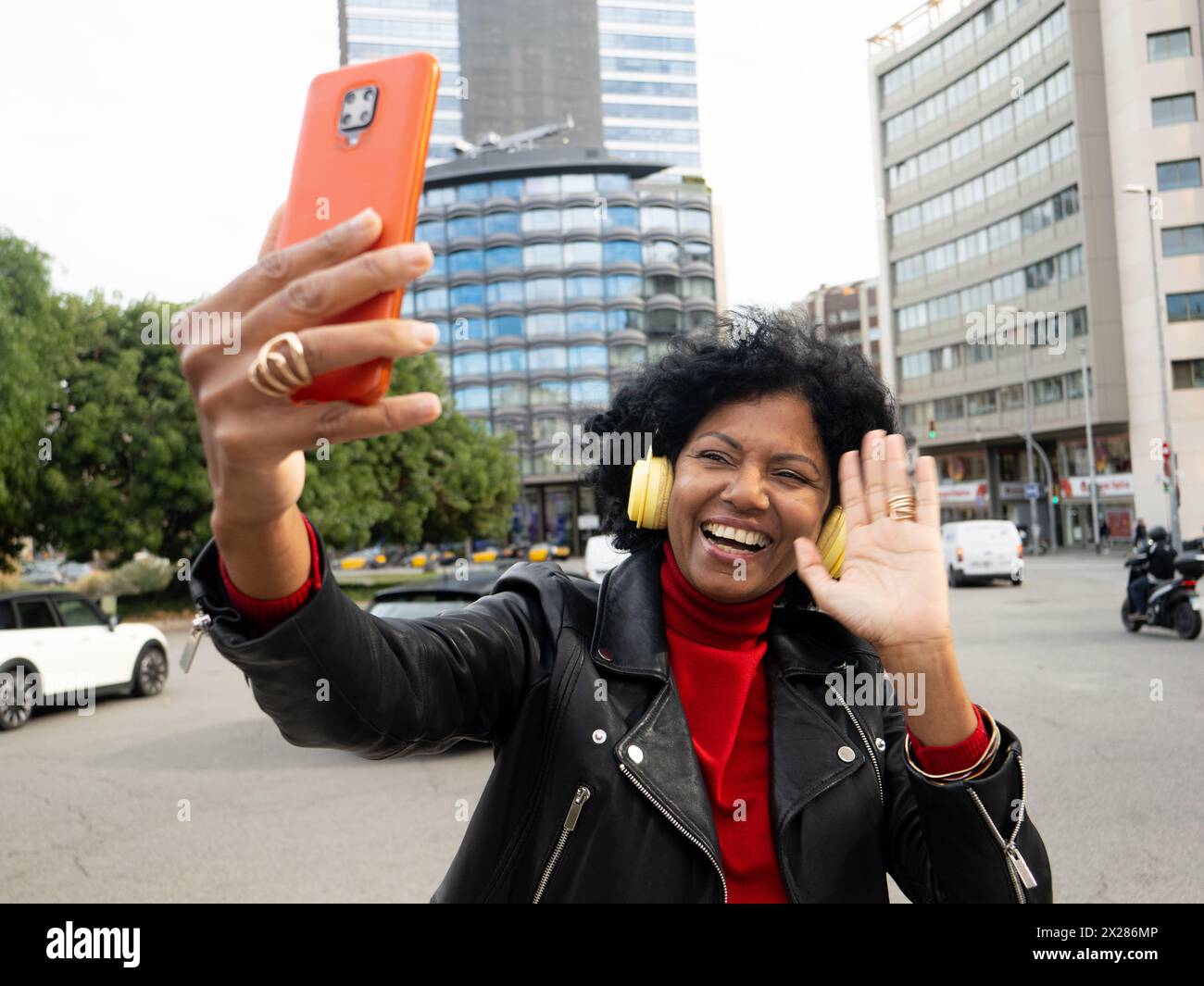 Afro-américaine femme d'âge moyen influenceuse faisant une vidéo avec smartphone dans une ville Banque D'Images