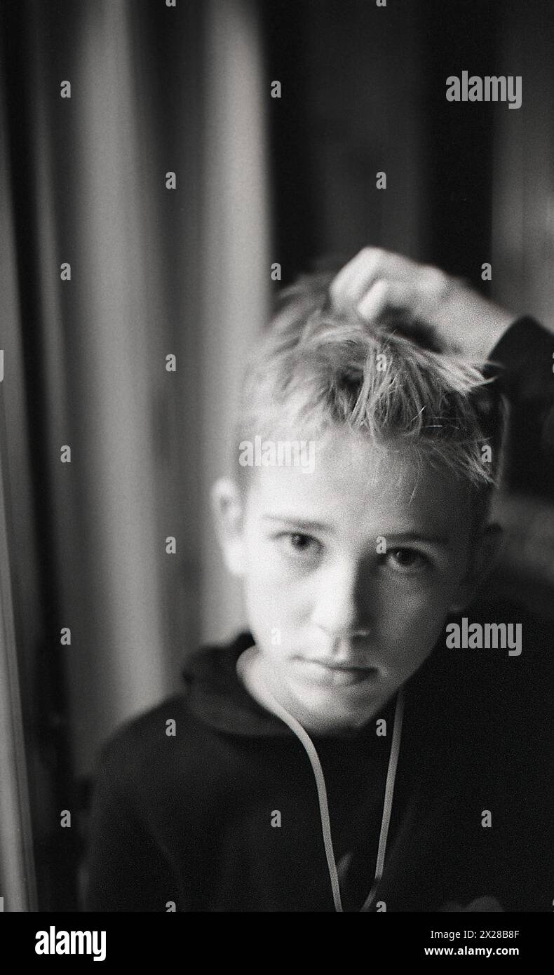 Portrait de la tête et des épaules d'un garçon adolescent grattant la tête Banque D'Images
