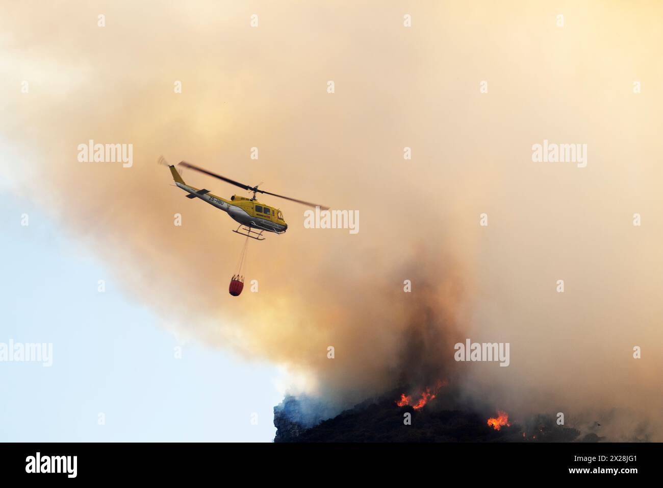 Hélicoptère larguant de l'eau sur un feu de forêt Banque D'Images