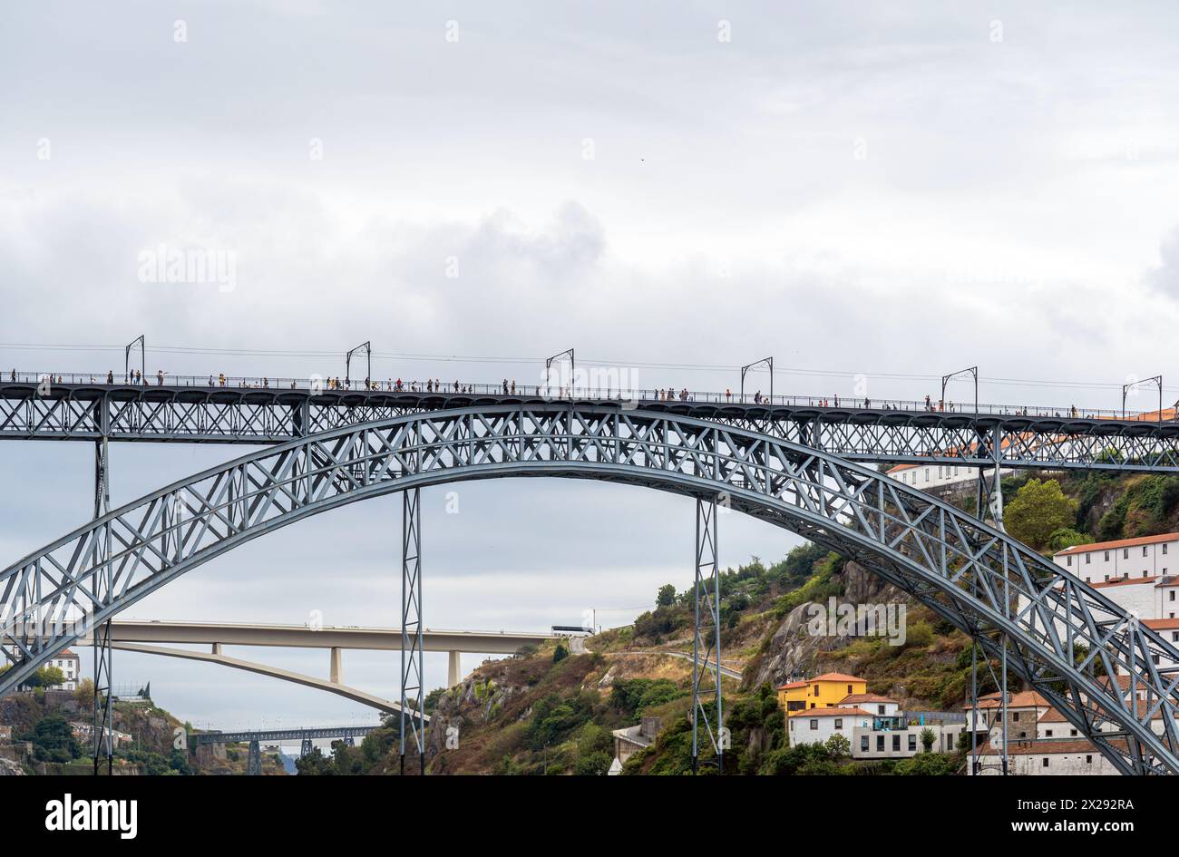 Vue frontale de la rivière du pont en acier Don Luis I avec des gens marchant, prenant des photos et posant et trois autres ponts en arrière-plan de Banque D'Images