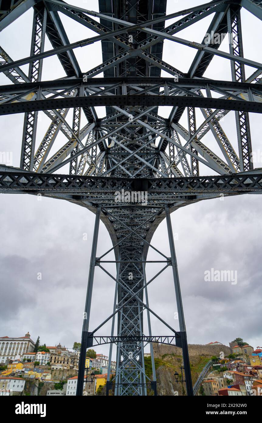 Vue en perspective de dessous avec des détails de rivets et de la structure métallique du pont en acier Don Luis I à Porto avec des nuages de pluie en arrière-plan et Banque D'Images