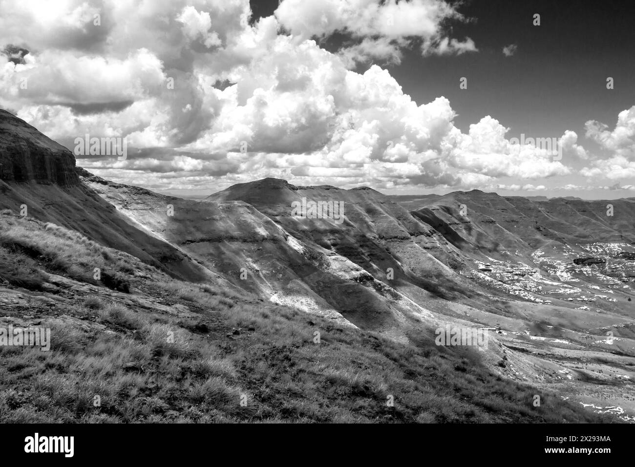 Nuages se rassemblant le long d'une crête de montagne dans les montagnes Drakensberg à la frontière entre le Lesotho et l'Afrique du Sud en noir et blanc Banque D'Images