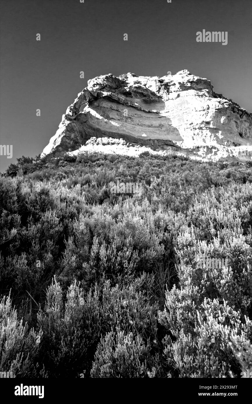 Imposante falaise de grès avec une petite arche en noir et blanc dans les montagnes Drakensberg en Afrique du Sud Banque D'Images