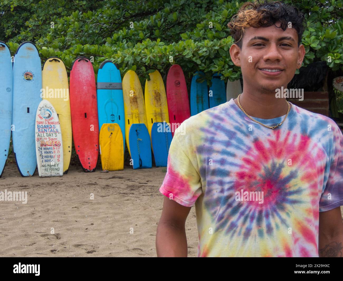 Jeune homme et planches de surf à louer sur une plage à Puerto Viejo de Talamanca sur la côte caribéenne du Costa Rica Banque D'Images