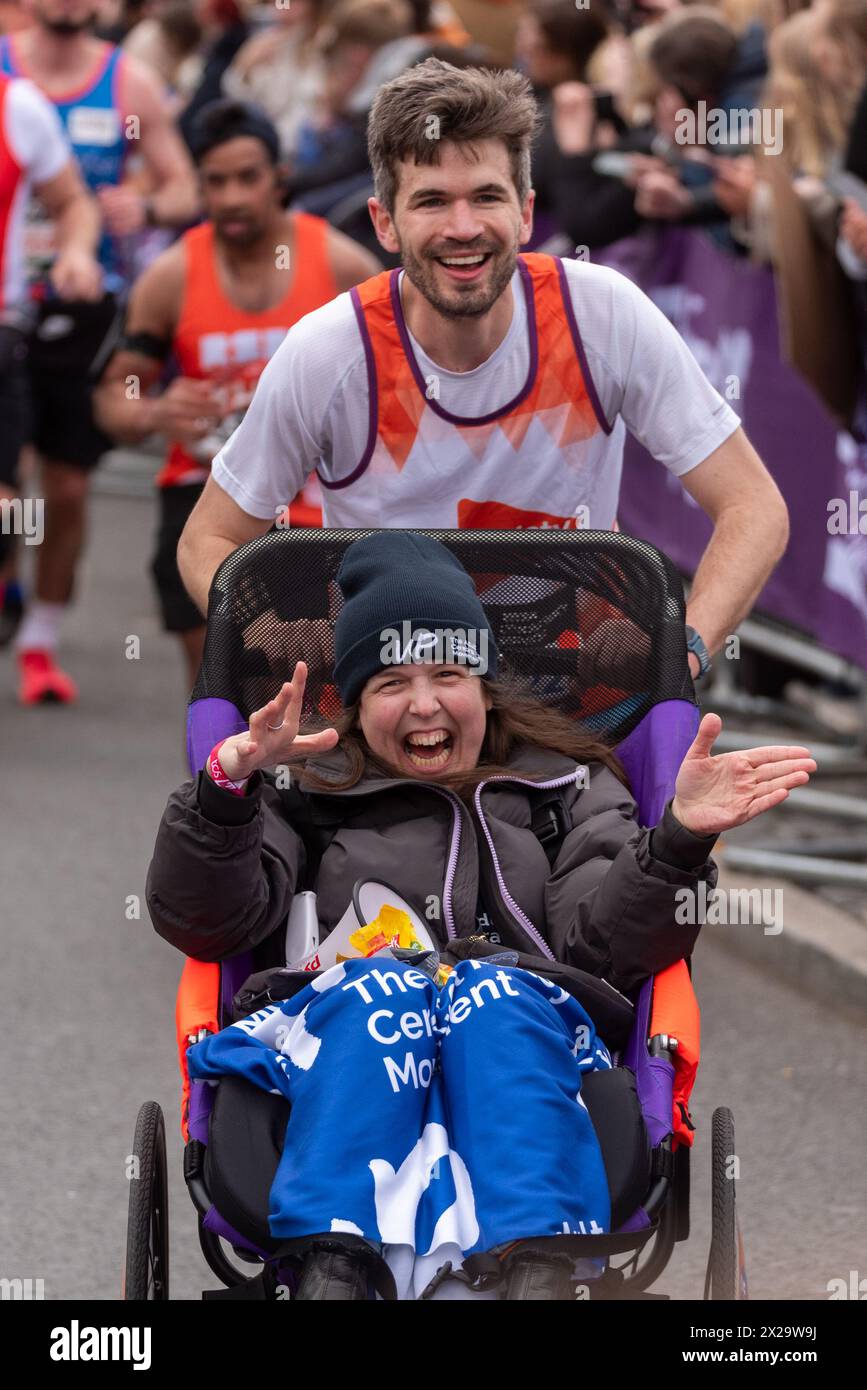 Tower Hill, Londres, Royaume-Uni. 21 avril 2024. Environ 50 000 personnes participent au marathon TCS de Londres 2024, y compris les meilleurs coureurs d’élite et athlètes en fauteuil roulant au monde. Les masses de coureurs de club et de fun les suivent, avec beaucoup amassant de grosses sommes pour la charité et courant souvent en tenue de fantaisie et visant à Guinness World Records pour diverses classes. La comédienne Rosie Jones poussée par Ivo Graham, amassant des fonds pour la Société de la sclérose en plaques et UP - le mouvement de paralysie cérébrale adulte Banque D'Images