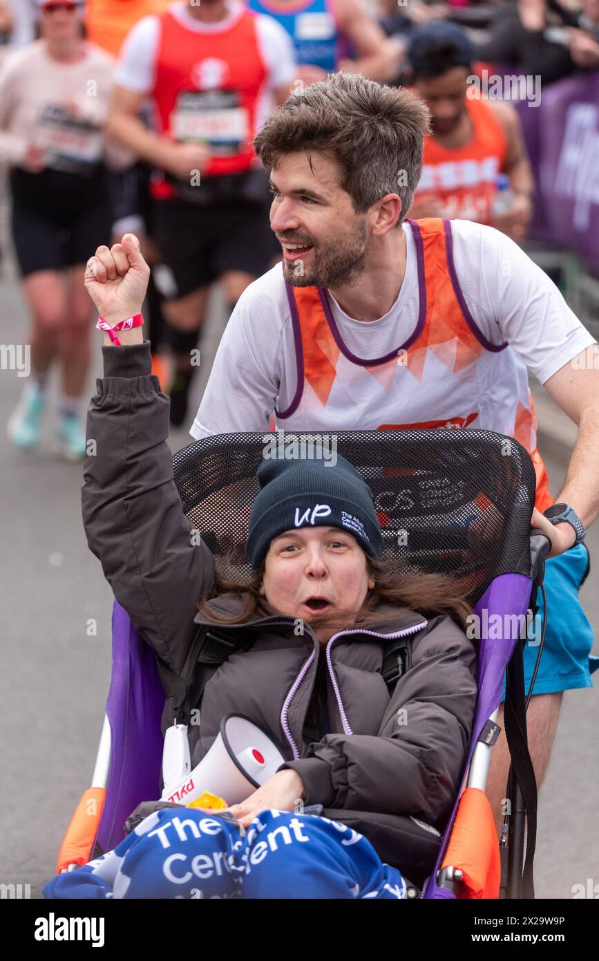 Tower Hill, Londres, Royaume-Uni. 21 avril 2024. Environ 50 000 personnes participent au marathon TCS de Londres 2024, y compris les meilleurs coureurs d’élite et athlètes en fauteuil roulant au monde. Les masses de coureurs de club et de fun les suivent, avec beaucoup amassant de grosses sommes pour la charité et courant souvent en tenue de fantaisie et visant à Guinness World Records pour diverses classes. La comédienne Rosie Jones poussée par Ivo Graham, amassant des fonds pour la Société de la sclérose en plaques et UP - le mouvement de paralysie cérébrale adulte Banque D'Images