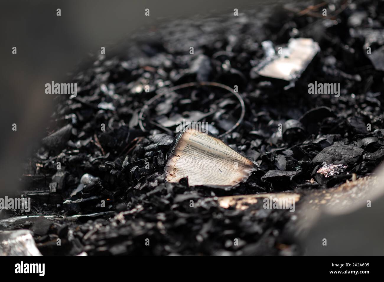 Un livre brûlé sur un tas de cendres, les restes de pages dans une maison brûlée Banque D'Images
