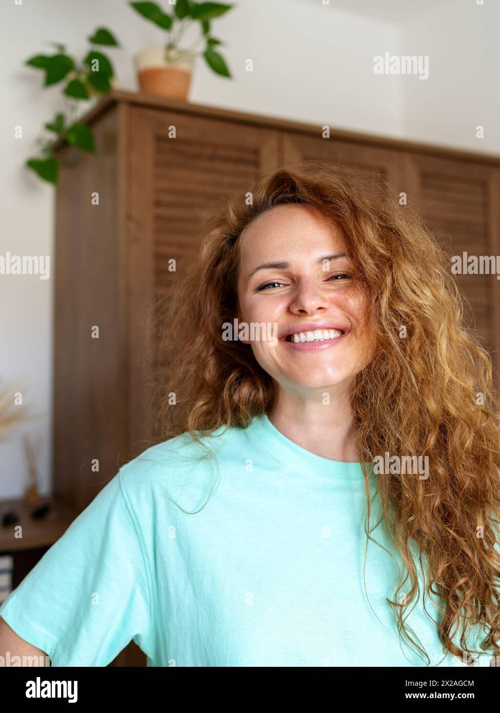 Portrait du bonheur authentique de la jeune femme bouclée à la maison. Banque D'Images