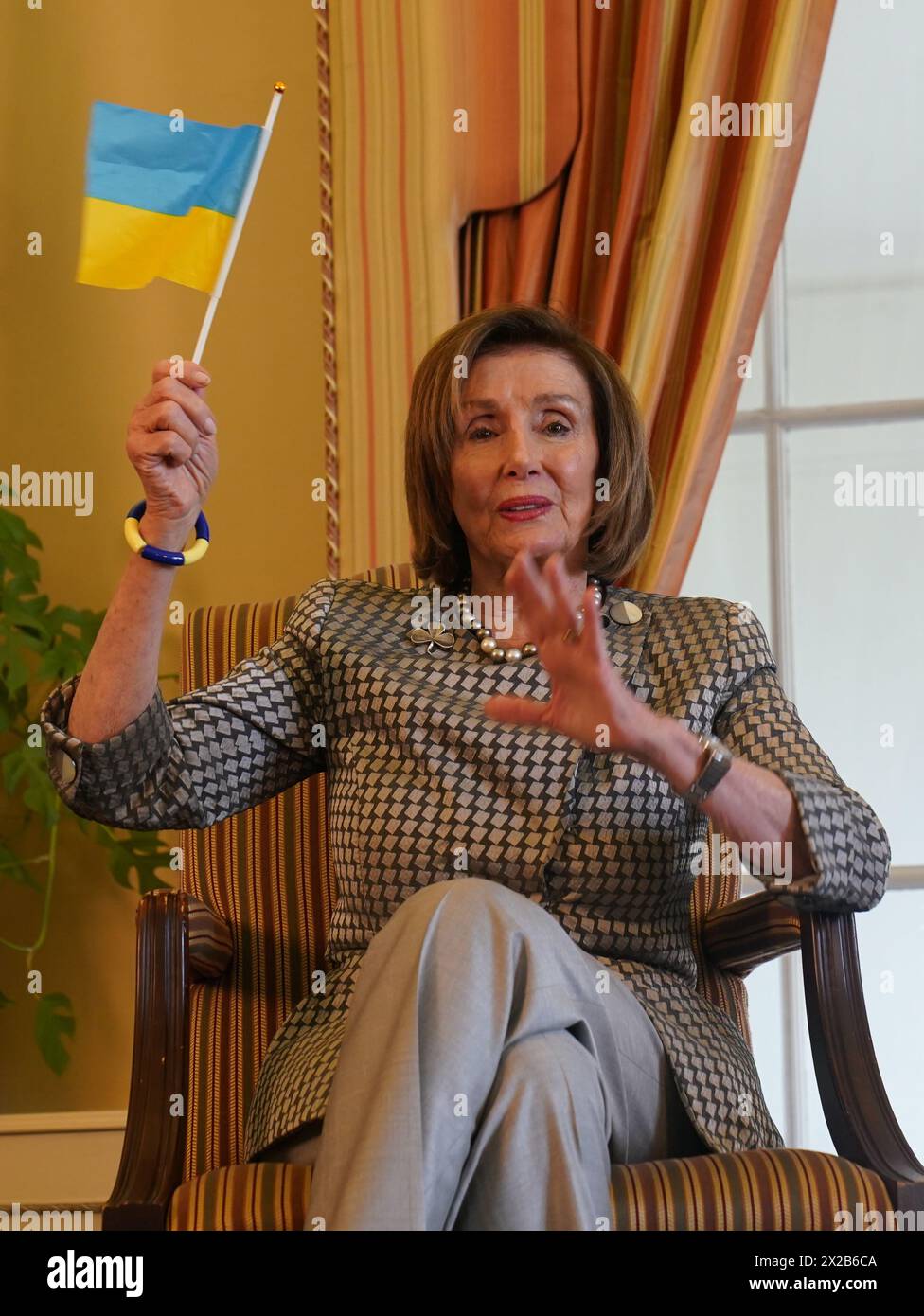 Nancy Pelosi, ancienne présidente de la Chambre des représentants des États-Unis, tient un drapeau ukrainien lors d'une conversation au coin du feu avec l'ambassadrice des États-Unis en Irlande Claire Cronin à la résidence de l'ambassadeur, Phoenix Park, Dublin. Date d'émission : dimanche 21 avril 2024. Banque D'Images