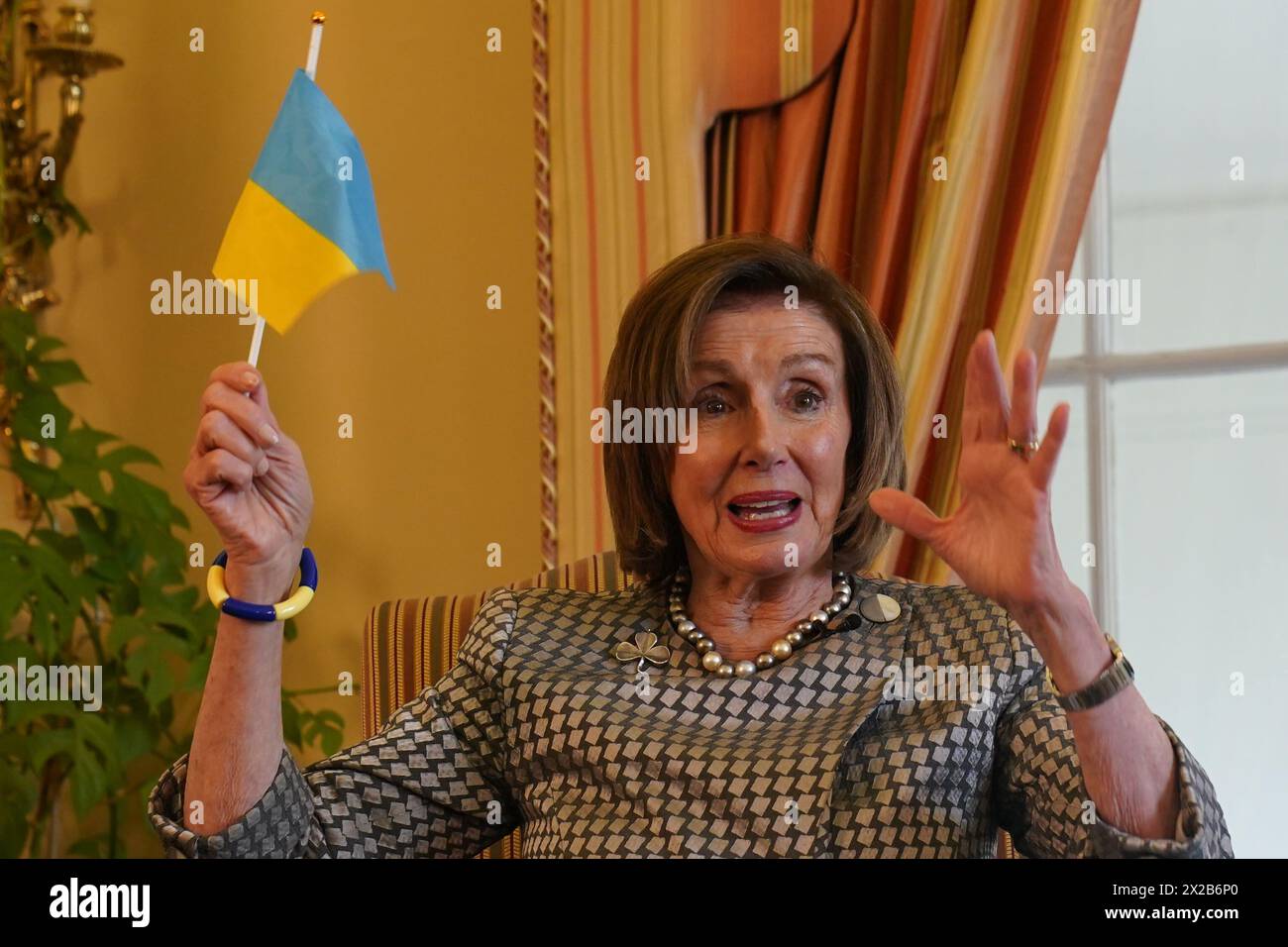 Nancy Pelosi, ancienne présidente de la Chambre des représentants des États-Unis, tient un drapeau ukrainien lors d'une conversation au coin du feu avec l'ambassadrice des États-Unis en Irlande Claire Cronin à la résidence de l'ambassadeur, Phoenix Park, Dublin. Date d'émission : dimanche 21 avril 2024. Banque D'Images