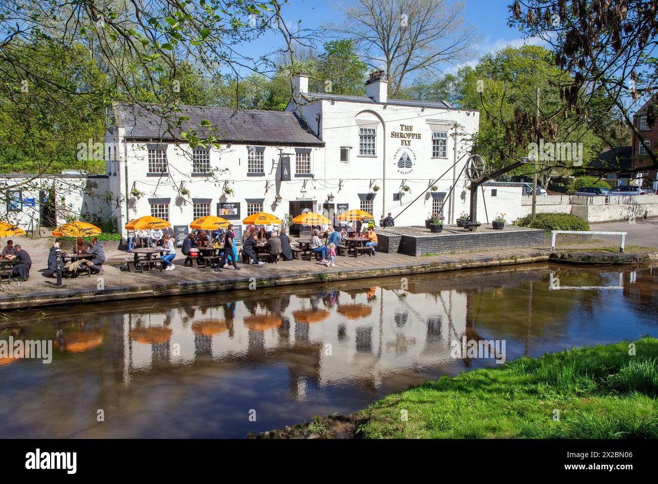 Les gens assis à l'extérieur mangeant et buvant au pub au bord du canal le Shroppie volent dans le village du Cheshire d'Audlem Cheshire en Angleterre Banque D'Images