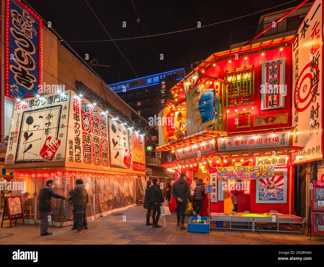 osaka, japon - 04 déc. 2023 : magasin d'attractions de tir et restaurant japonais de brochettes frites kushikatsu illuminé la nuit Banque D'Images