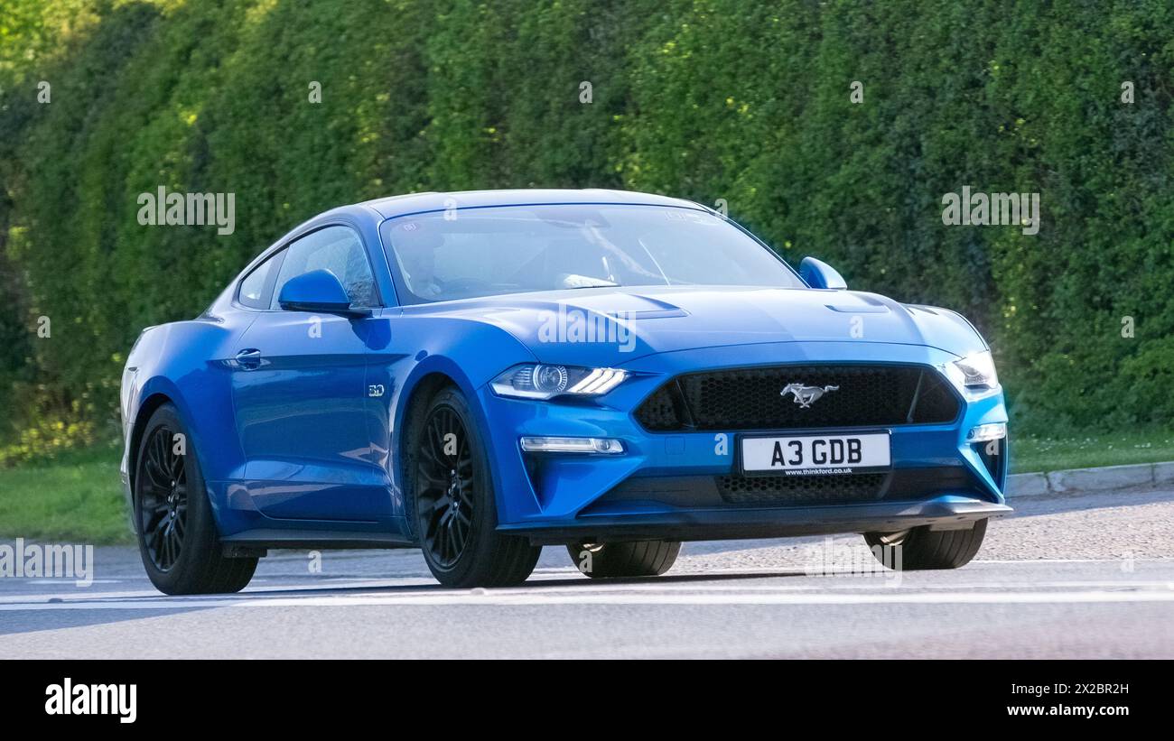 Bicester, UK- Apr 21st2024 : 2019 voiture classique Ford Mustang bleue conduisant sur une route britannique Banque D'Images