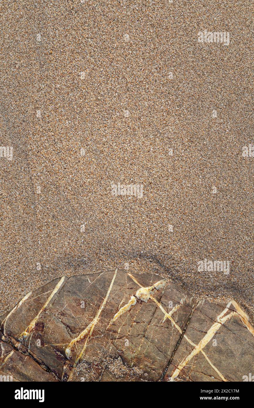 Sable fin et rochers sablonneux doux intacts sur une plage par une journée ensoleillée, vue d'en haut. Fond de sable naturel texturé abstrait, vue de dessus. Copier l'espace. Banque D'Images