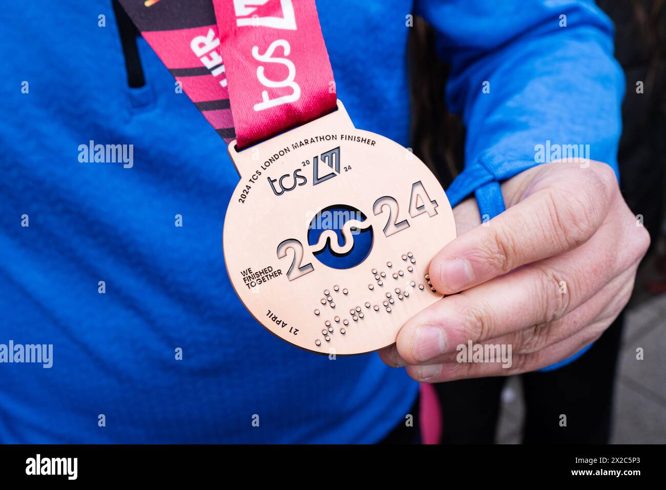 Londres, Royaume-Uni. 21 avril 2024. Un finisseur du Marathon affiche sa médaille d'accomplissement. Plus de 50 000 coureurs ont participé au marathon de Londres 2024. (Photo de Daniel Lai/SOPA images/SIPA USA) crédit : SIPA USA/Alamy Live News Banque D'Images