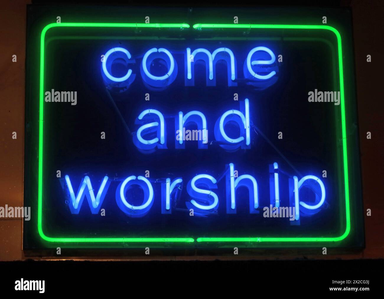 Panneau de néon à la nuit Oldham Street dans le centre-ville de Manchester - Come and Worship, M1 1JR Banque D'Images