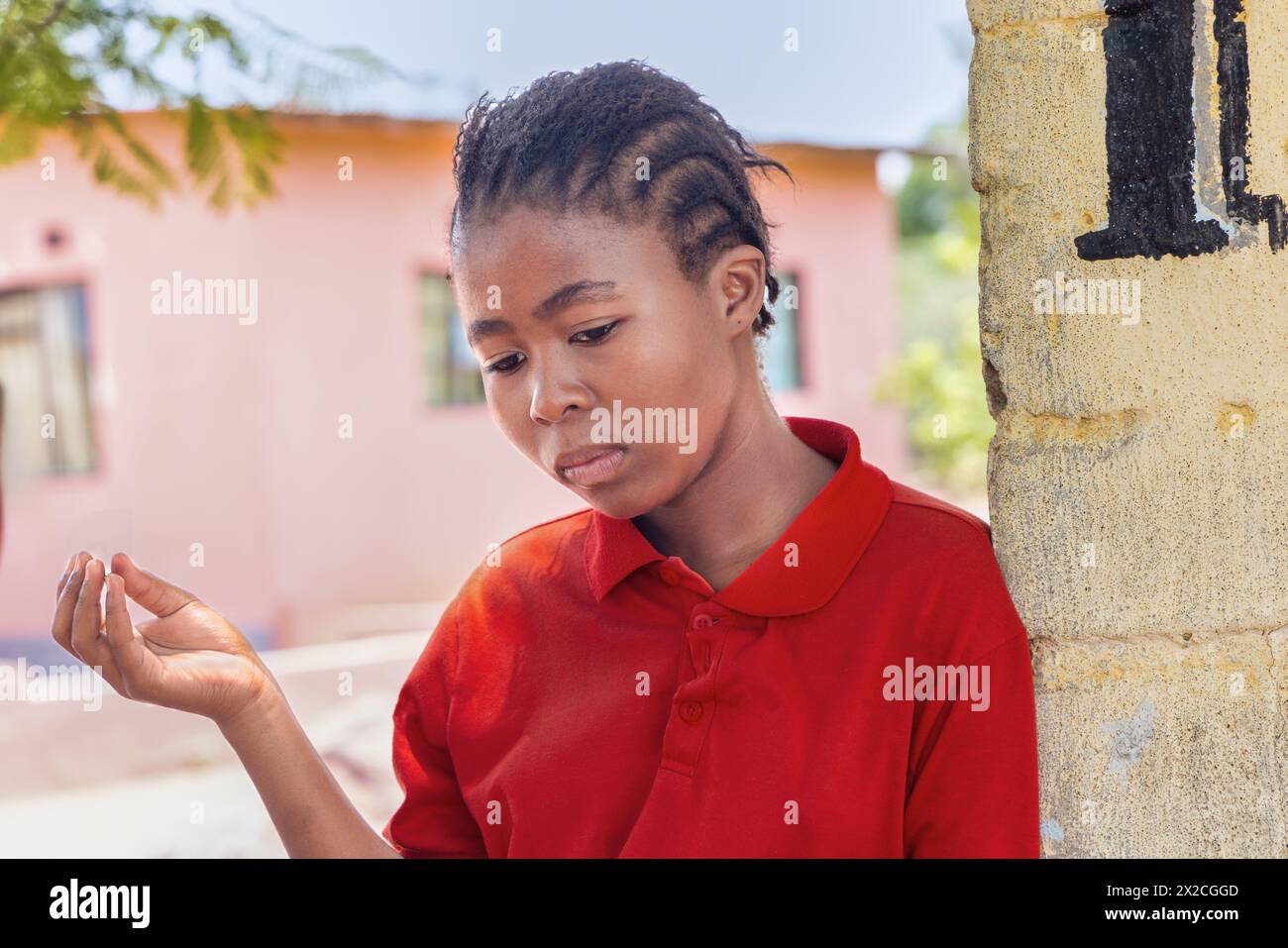 adolescente africaine avec des tresses devant la maison dans le township pauvre, établissement informel Banque D'Images
