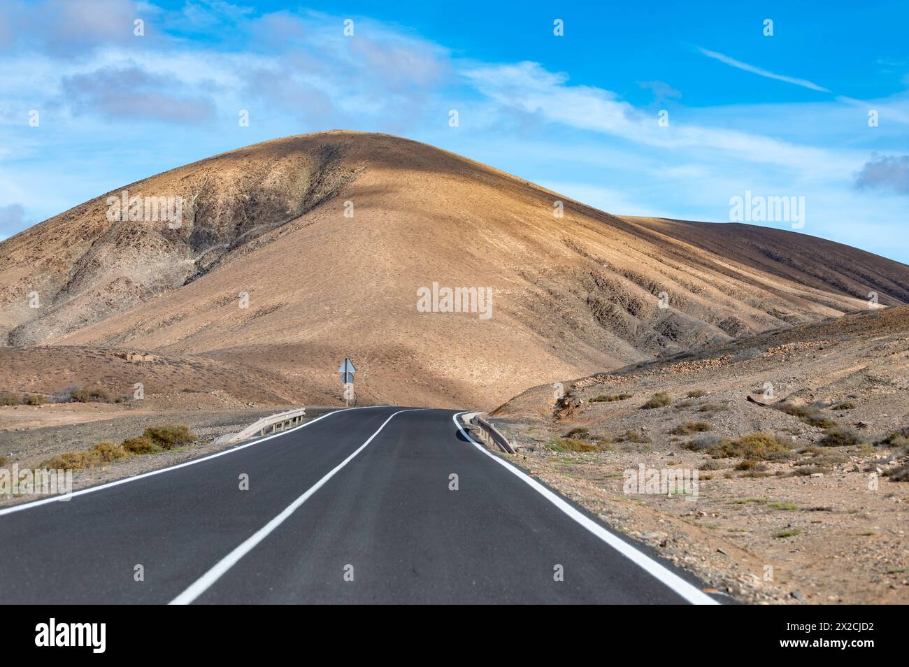 Route asphaltée de montagne sur les collines basales reculées colorées et les montagnes du massif de Betancuria, Fuerteventura, îles Canaries, Espagne, destination de voyage Banque D'Images