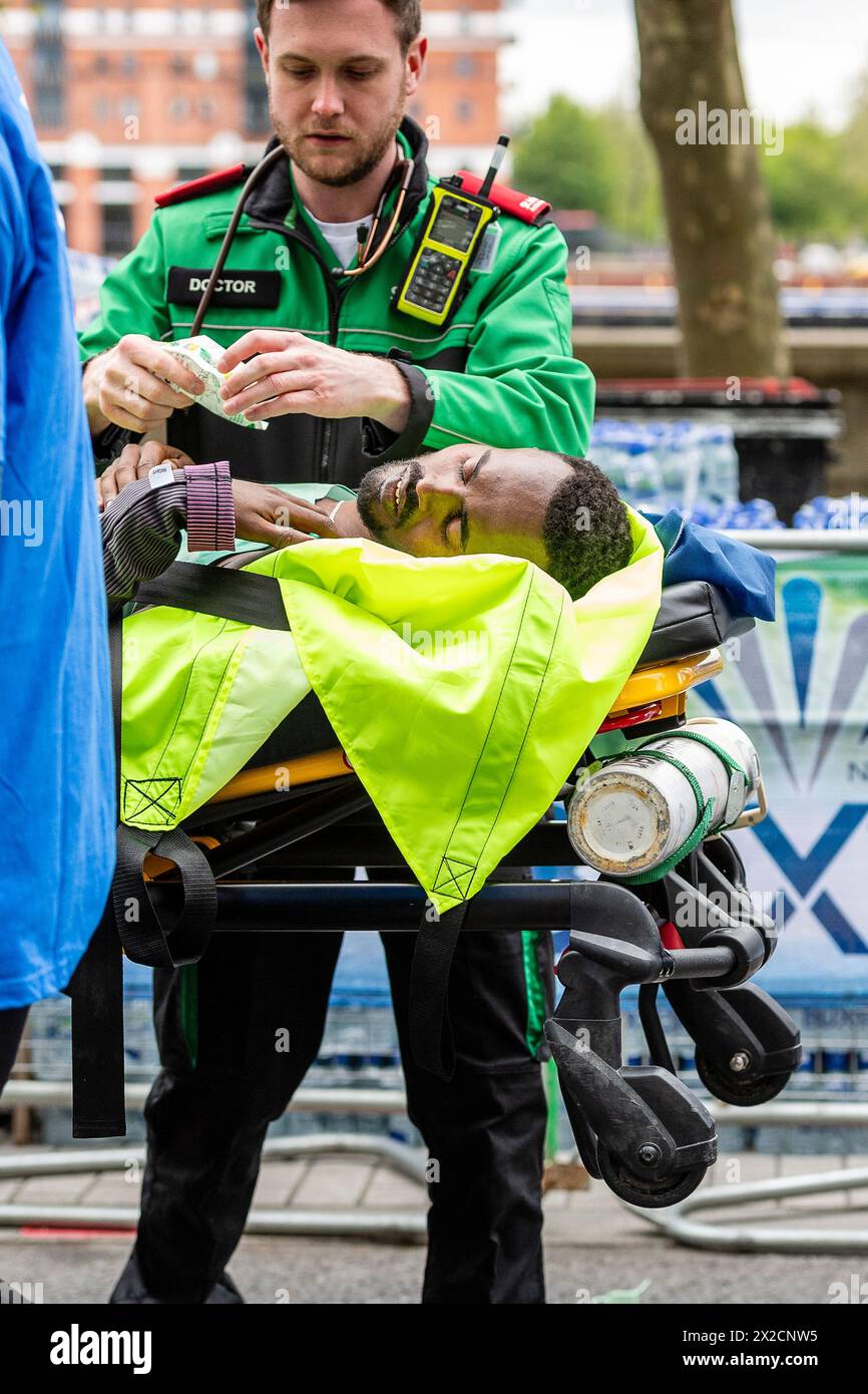 Londres, Royaume-Uni. 21 avril 2024. Milkesa Mengesha s'effondre à 39 km, et est aidé par des bénévoles et du personnel de l'Ambulance Saint-Jean, Milkesa Mengesha d'Ethiopie participe à la course d'élite masculine lors du marathon TCS de Londres 2024 le 21 avril Angleterre crédit : vue Studios/Alamy Live News Banque D'Images