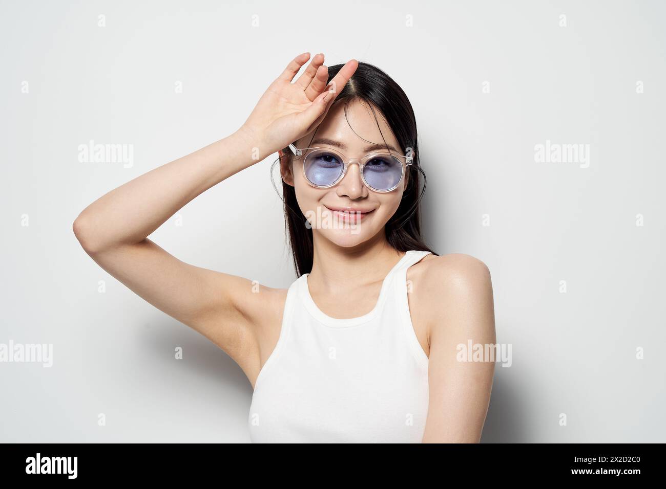 Une femme asiatique portant des lunettes de soleil et souriante Banque D'Images