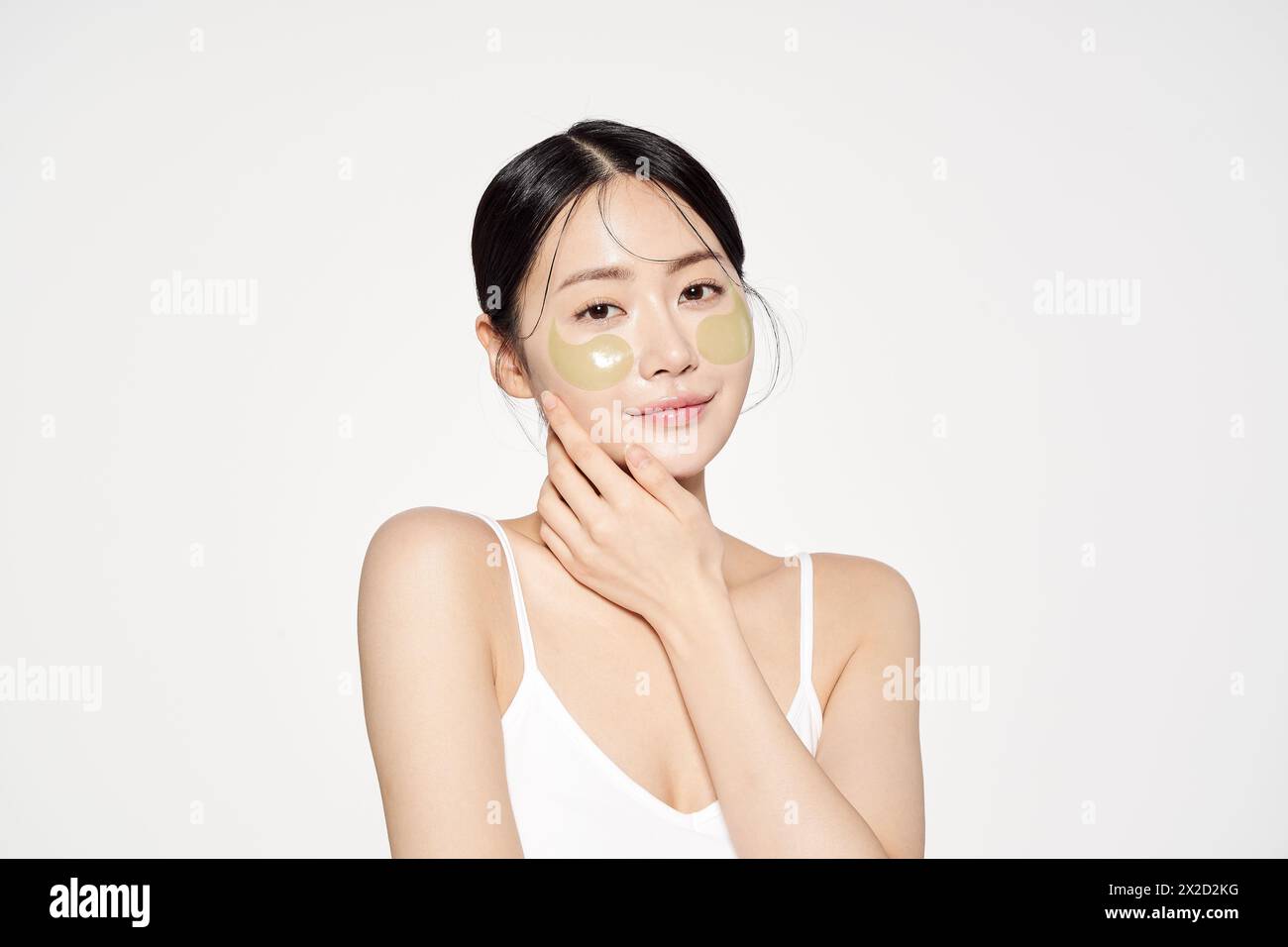 Femme asiatique posant avec des plaques oculaires sur les deux joues Banque D'Images