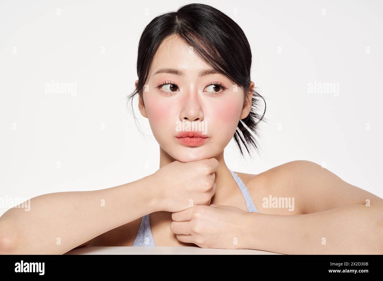 Une femme asiatique soutenant son visage avec son poing Banque D'Images