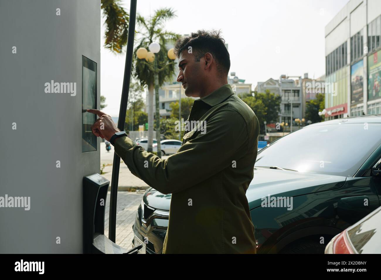 Propriétaire de voiture électrique payant pour la recharge Banque D'Images