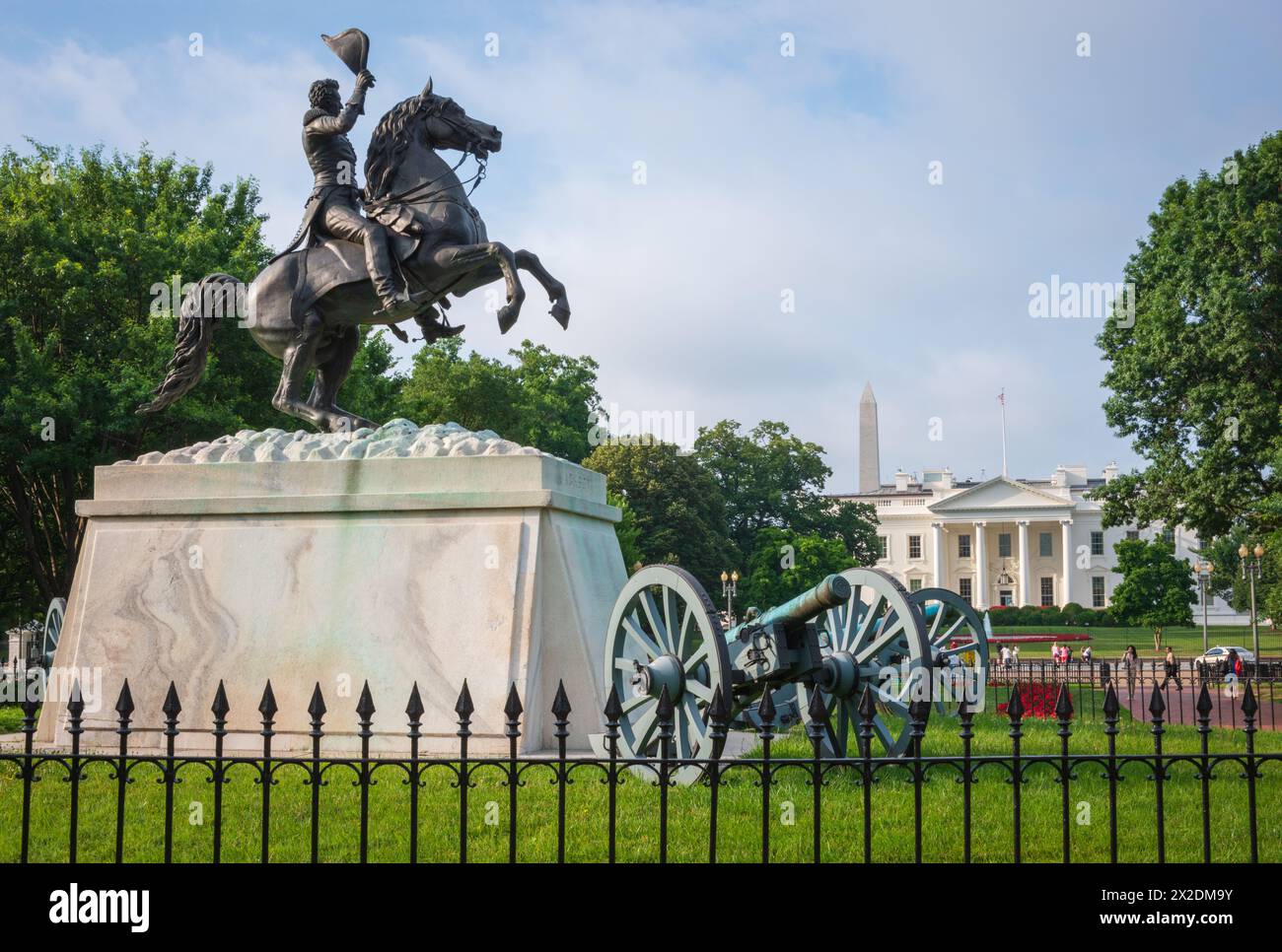 Au-delà d'une clôture en fer, la statue équestre et son canon se dressent sur la place Lafayette avec la Maison Blanche parmi les arbres, à Washington, DC. Banque D'Images