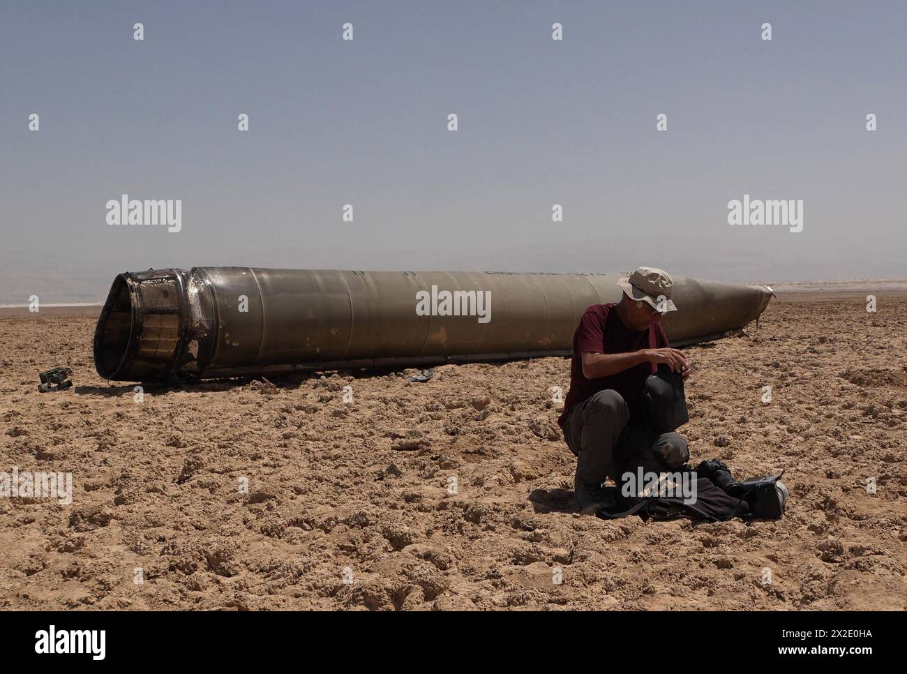 Un drone survole les restes d’un missile balistique iranien intercepté au-dessus d’Israël lors de l’assaut iranien trouvé sur les rives de la mer morte, en Israël. L'ogive de 500 kilogrammes (1 100 livres) du missile Emad avait volé plus de 1 500 kilomètres de l'Iran à Israël en 12 minutes et était l'un des 120 missiles balistiques tirés sur Israël. Banque D'Images