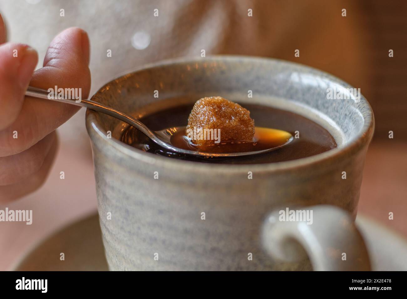 Morceau de sucre sur une cuillère à café fondant dans une tasse de café chaude Banque D'Images