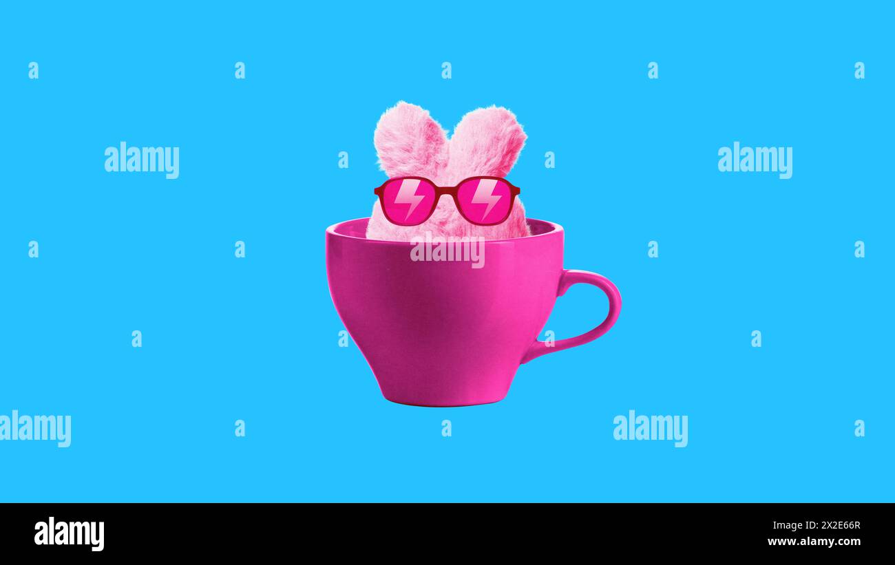 Lapin rose portant des lunettes de soleil assis à l'intérieur de la tasse sur fond bleu. Collage d'art contemporain. Jouet, magasin d'accessoires, divertissement. Banque D'Images