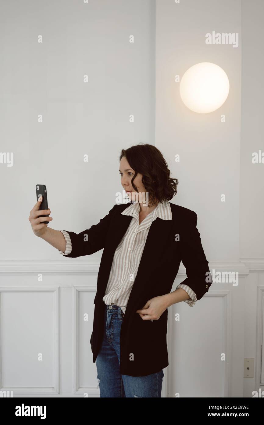 Femme d'affaires tient le téléphone pendant une réunion d'appel vidéo Banque D'Images
