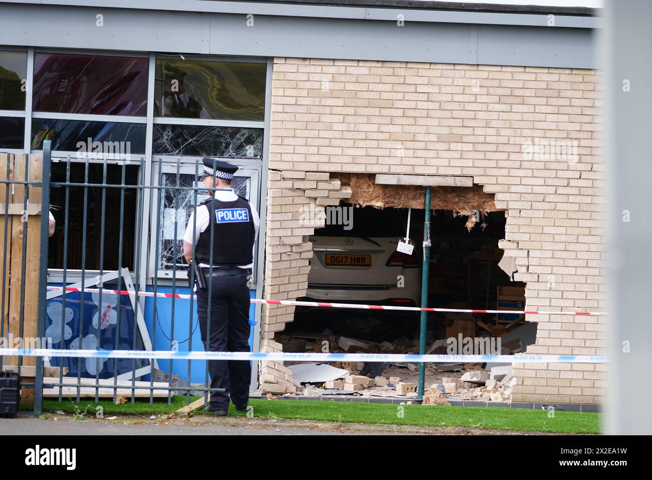 Les policiers se tiennent à côté des débris et des dommages causés à l'école primaire Beacon Church of England, à Anfield, Liverpool, après qu'une voiture s'est écrasée dans le bâtiment. Date de la photo : lundi 22 avril 2024. Banque D'Images
