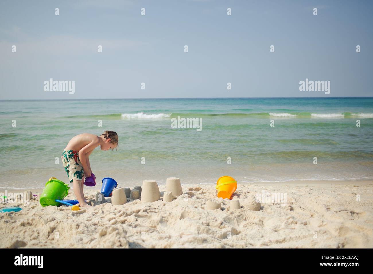 Enfants construisant des châteaux de sable avec des jouets de plage colorés Banque D'Images