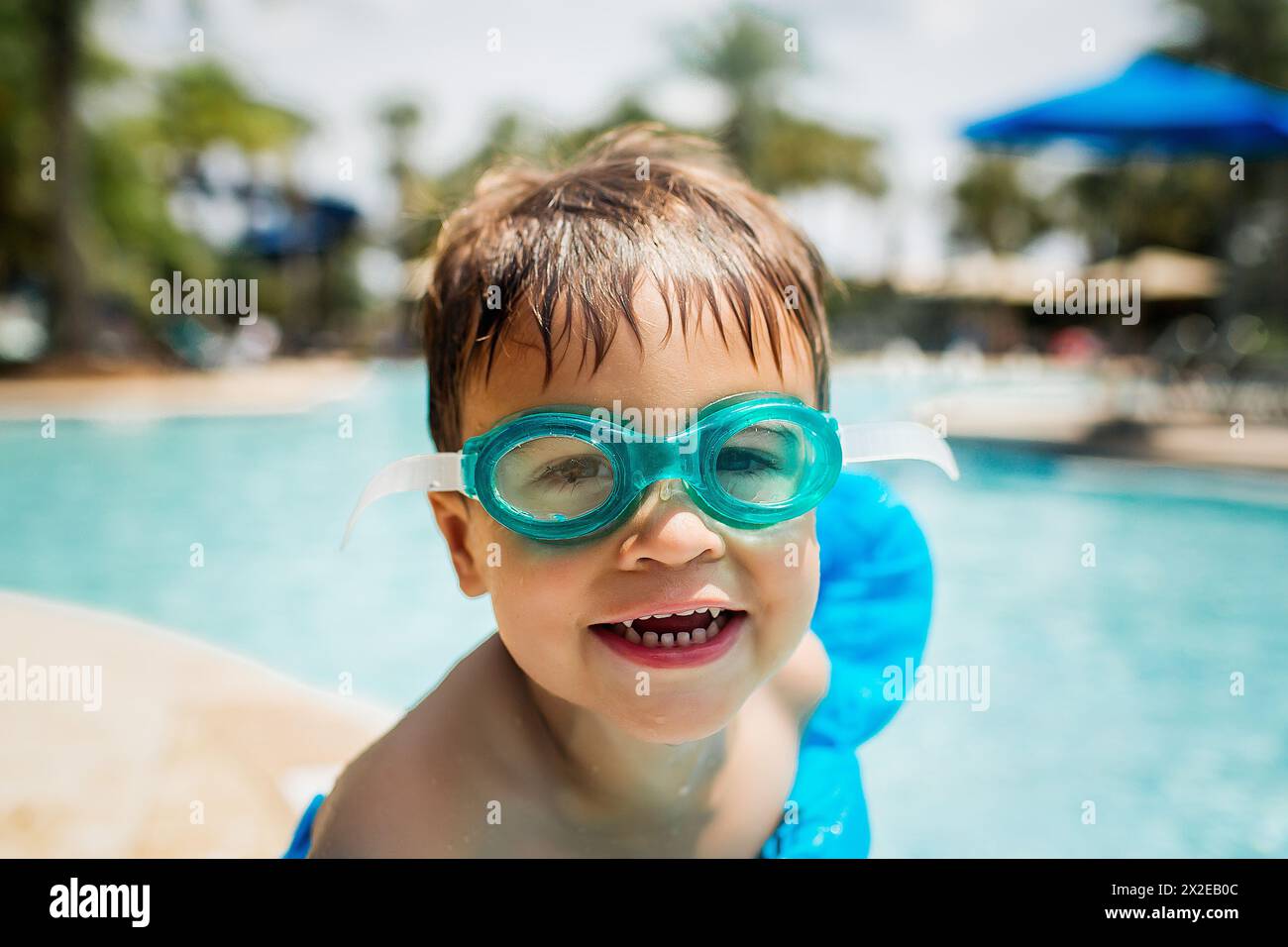 Enfant souriant dans des lunettes prêt pour le plaisir au bord de la piscine Banque D'Images