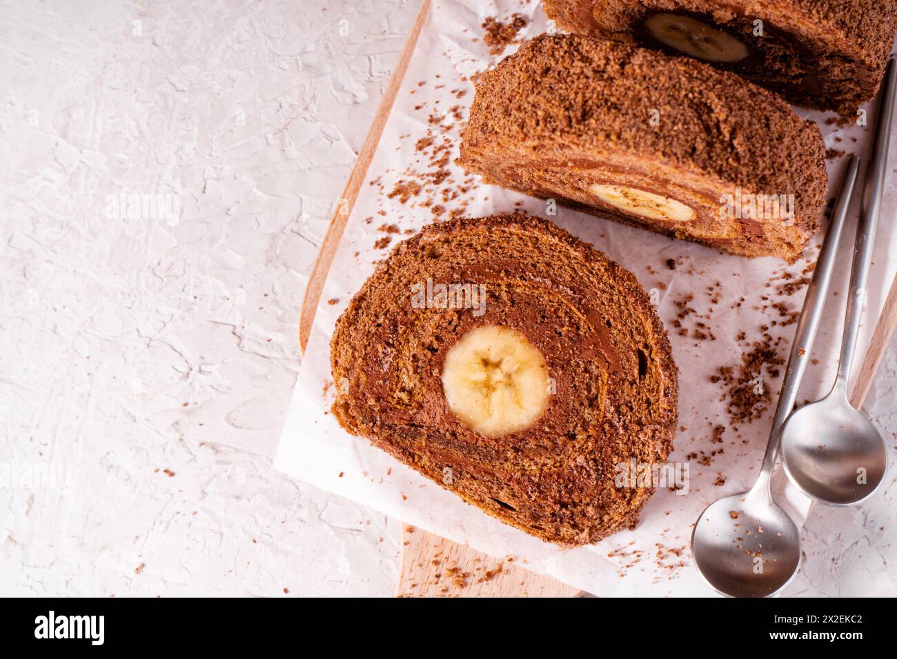 Gâteau rouleau suisse au chocolat à la banane, rouleau d'éponge avec garniture au chocolat et banane Banque D'Images