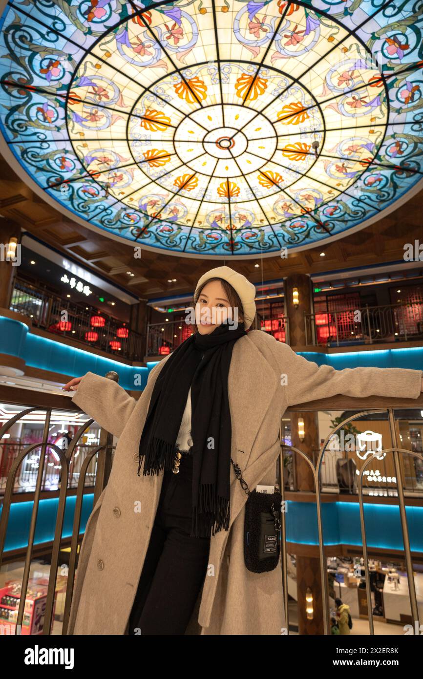 Une femme chinoise à l'intérieur portant des vêtements d'hiver par une journée froide à Shanghai, en Chine Banque D'Images