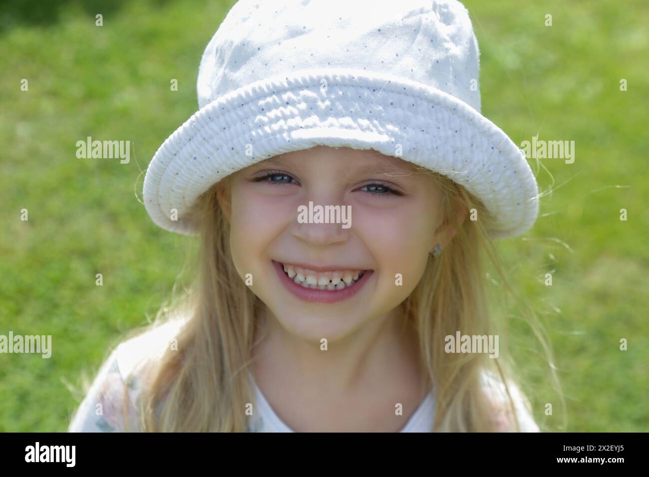 Portrait extérieur candide de petite fille heureuse avec chapeau de seau Banque D'Images