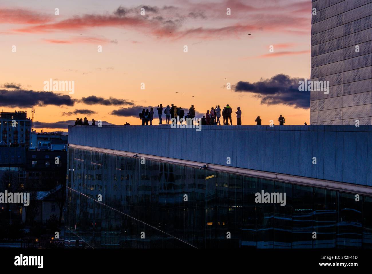 Touristes silhouettés par le coucher du soleil à l'Opéra d'Oslo, Norvège Banque D'Images