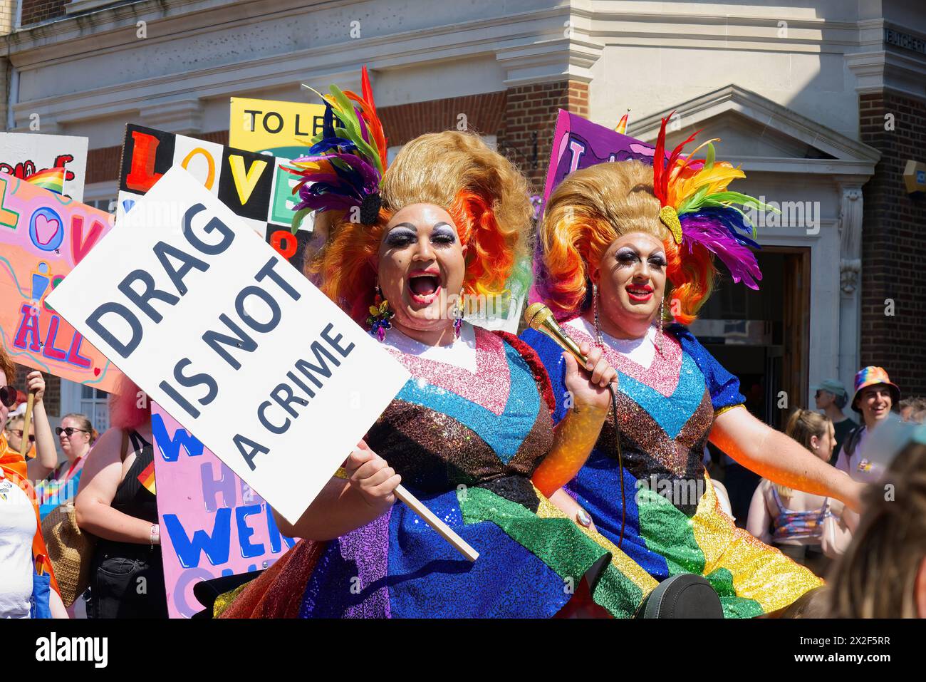 Canterbury, Kent, Royaume-Uni - 06.10.2023, deux drag Queens colorés tenant une pancarte « Drag is not a crime » au défilé Canterbury Pride 2023 Banque D'Images