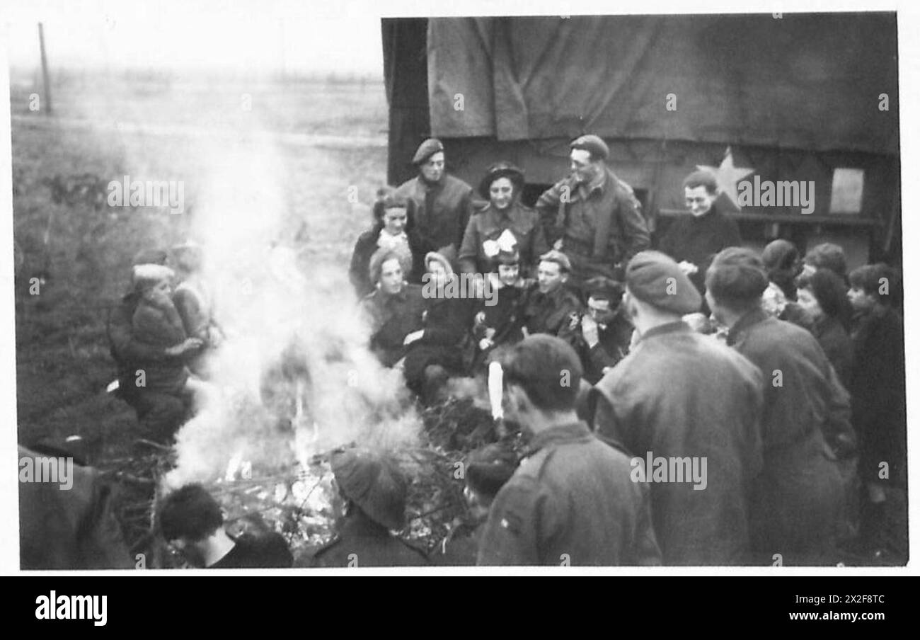 NOËL EN PREMIÈRE LIGNE - en attendant que le dîner soit préparé, les soldats donnent une chanson-chant autour du feu de camp dans lequel leurs amis néerlandais, avec leurs enfants, rejoignent l'armée britannique, 21e groupe d'armées Banque D'Images