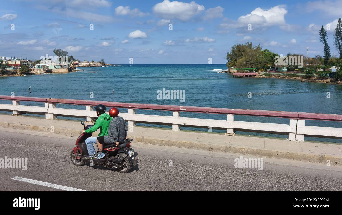 Deux cubains en vélo électrique dans le pont de Varadero, Cuba Banque D'Images