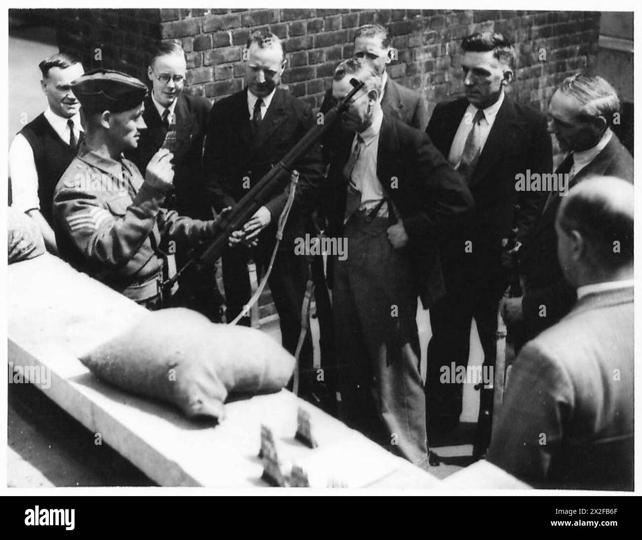 Un sergent instructeur démontre le chargement de fusil à des fonctionnaires L.D.V.s pendant l'entraînement de l'armée britannique. Banque D'Images