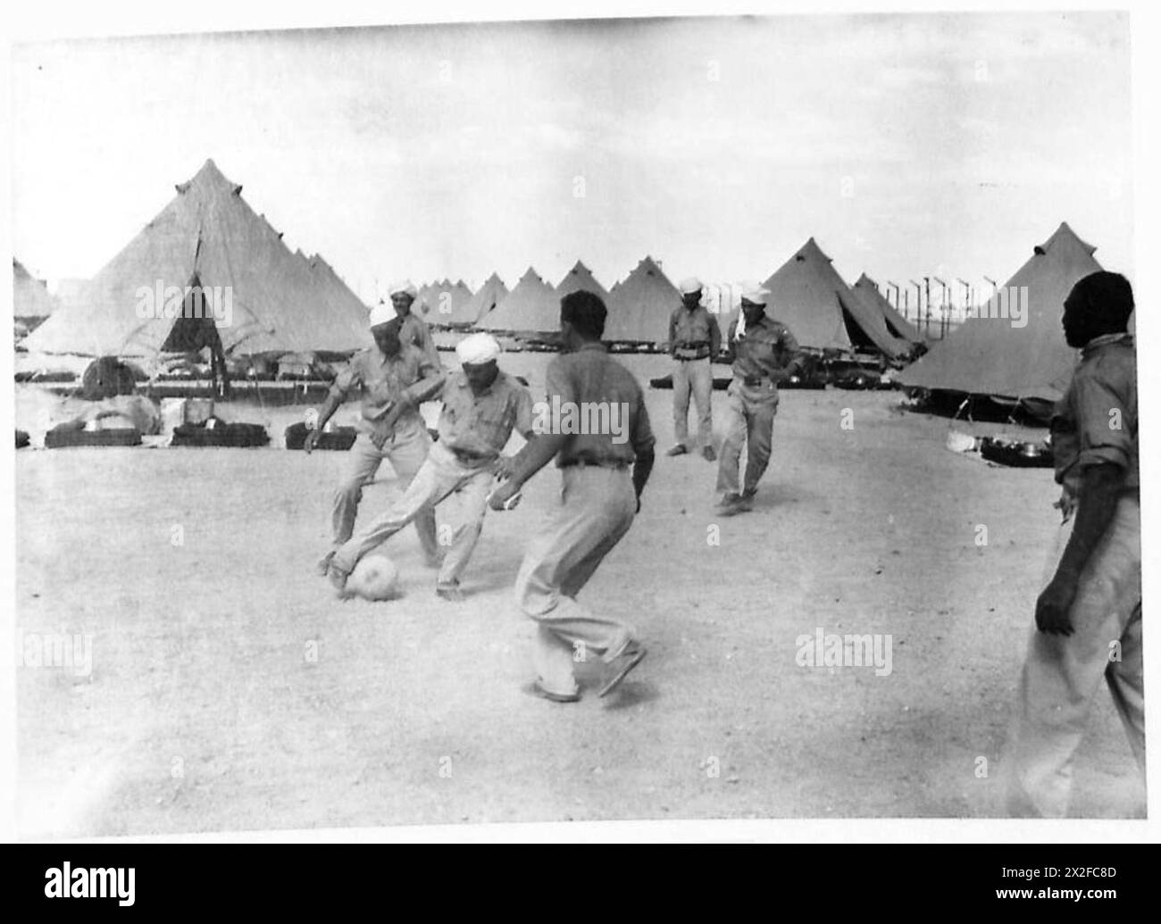 Les prisonniers de guerre dans un camp libyen participent au football comme une forme de loisirs, sous la supervision du personnel de l'armée britannique. Banque D'Images