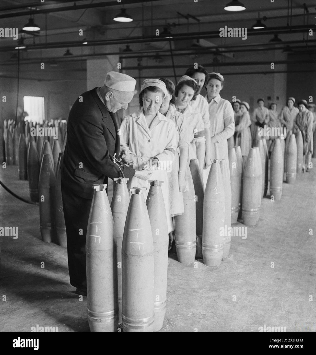 En 1939-1945, en Grande-Bretagne, un médecin examine les mains des travailleurs des munitions dans le cadre du bien-être et de la gestion du personnel dans l'industrie de guerre. Banque D'Images