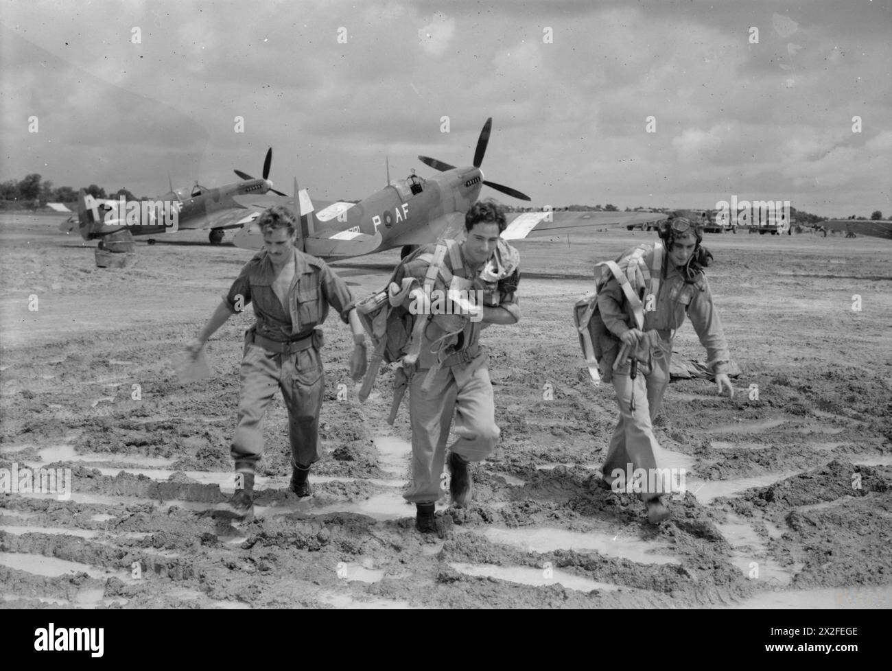 OPÉRATIONS DE LA ROYAL AIR FORCE EN EXTRÊME-ORIENT, 1941-1945. - Les pilotes du No. 607 Squadron RAF, quittent leur Supermarine Spitfire Mark VIIIs pour traverser l'aérodrome de Mingaladon, en Birmanie, après être revenus d'une sortie contre les troupes japonaises et de la navigation sur la rivière Sittang, (la bataille de Sittang Bend). Il s'agit (de gauche à droite) : du lieutenant de vol d A Pidgeon de Tadworth, Surrey ; de l'adjudant W G Yates de West Bridgford, Nottingham, et du sergent de vol R H Whittle de Bracknell, Berkshire Royal Air Force, unité de maintenance, 67 Banque D'Images