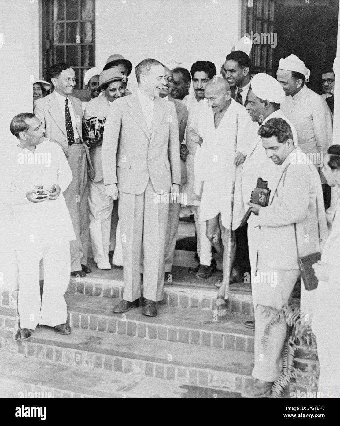 Sir Stafford Cripps s'entretient avec Mohandas Karamchand Gandhi sur les marches de Birla House, Delhi, lors de sa mission diplomatique en Inde. Ils sont entourés de journalistes et photographes indiens, des années 1940 Banque D'Images