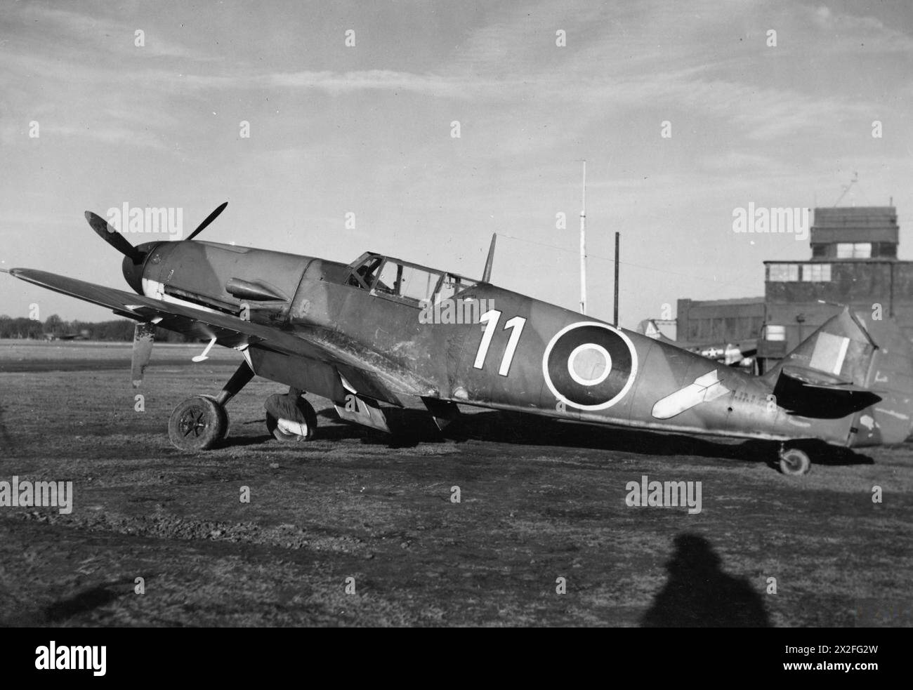 ROYAL AIR FORCE FIGHTER COMMAND, 1939-1945. - Messerschmitt Bf 109F-4/B, NN644, du No 1426 (Enemy Aircraft Circus) vol basé à Collyweston, Northamptonshire, stationné près de la tour de contrôle à Bassingbourn, Cambridgeshire, lors de la 11e tournée de l'unité des stations opérationnelles donnant des démonstrations aériennes. Bien qu'il soit peint aux couleurs de la RAF, l'avion conserve le marquage « White 11 » et le symbole de bombe de son ancienne unité de la Luftwaffe, 10 (Jabo)/JG26 Royal Air Force, vol, 1426 (Photographic reconnaissance) Banque D'Images