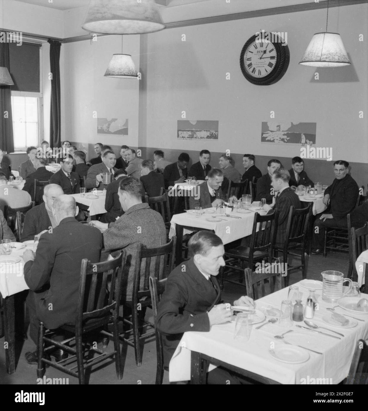 Les marins marchands mangent un repas dans la salle à manger animée du London Seamen's Home and Red Ensign Club, 1942. Banque D'Images