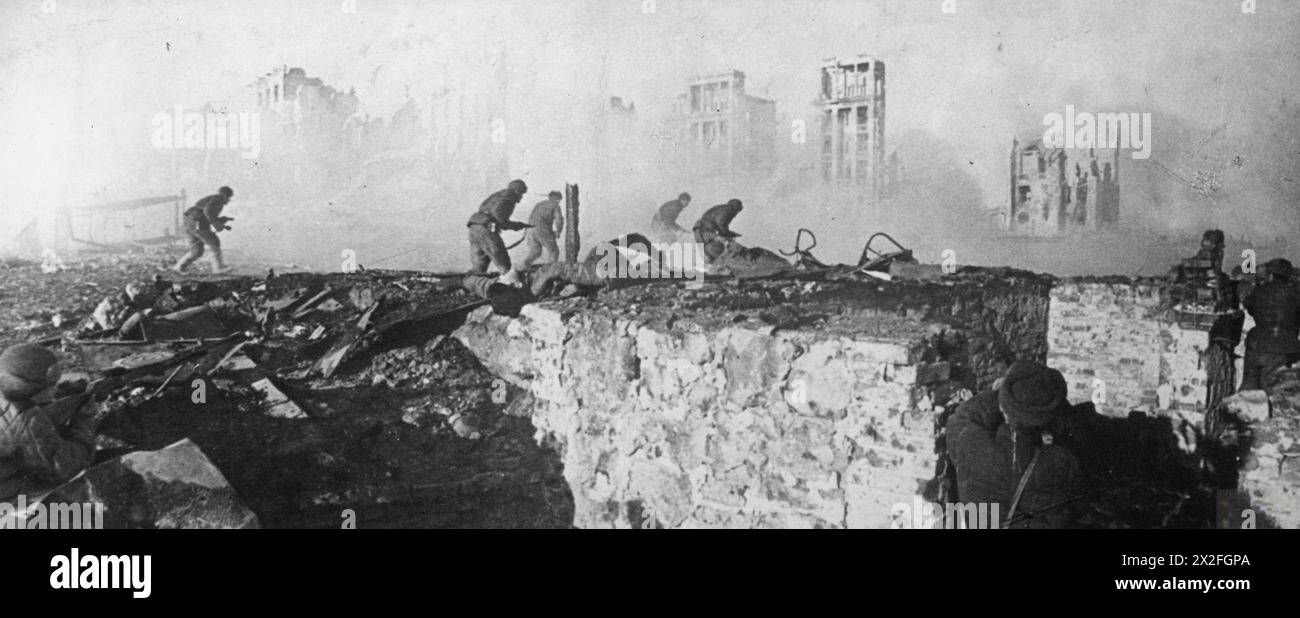LA BATAILLE DE STALINGRAD, 1942-1943 - les troupes russes courent en avant avec les ruines de Stalingrad en arrière-plan Banque D'Images